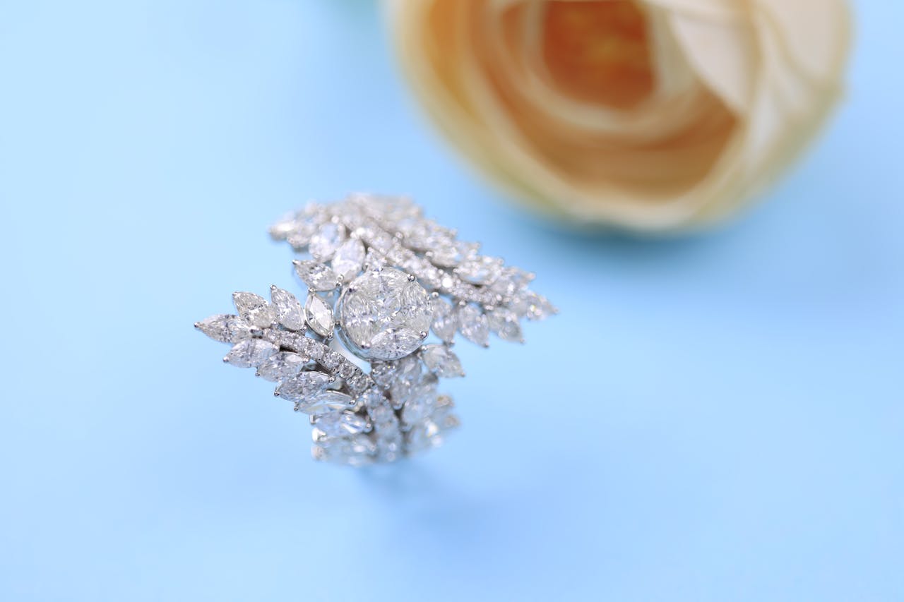 Beautiful diamond ring with delicate design against a light blue backdrop, symbolizing luxury and elegance.