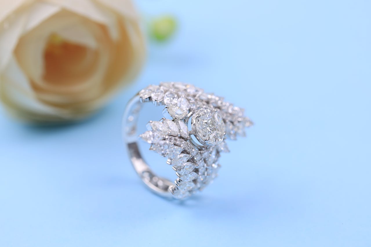 Close-up of a luxurious silver ring with diamonds on a soft blue background.